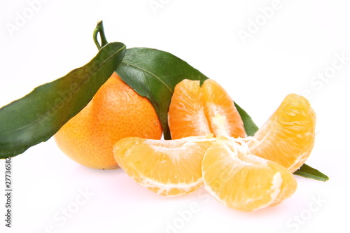 Mandarin with leaves and slices on white background
