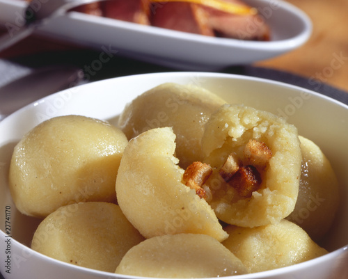 potato dumpling with an open potato dumpling above in white bowl