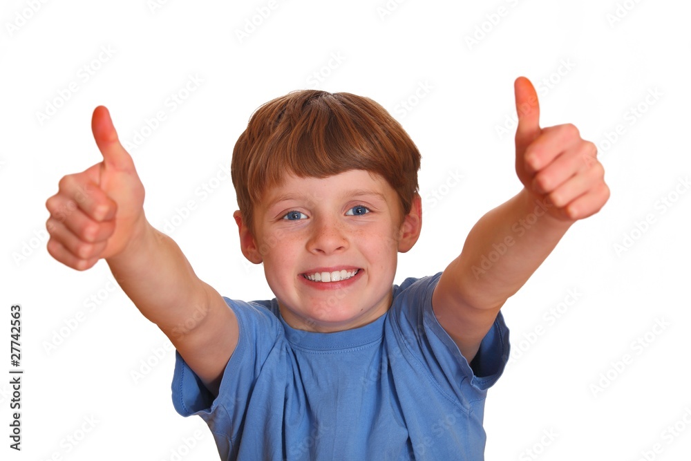 Lachender Junge zeigt mit den Daumen nach oben