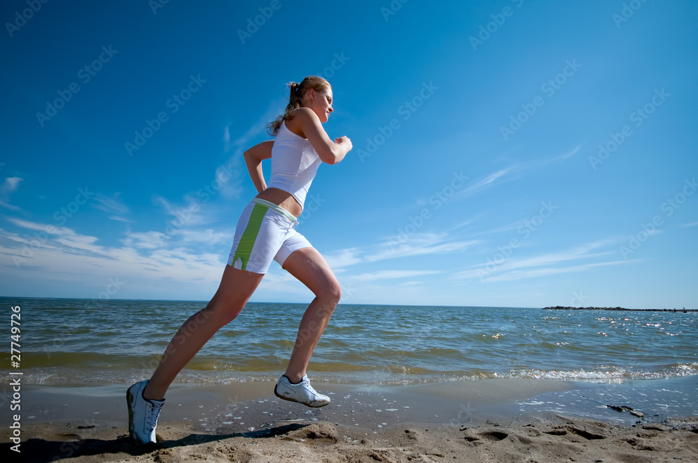 Sport woman running on beach Sport woman running on beach