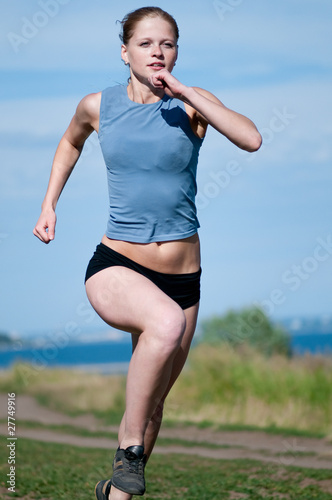 Young sport woman running on sunny day