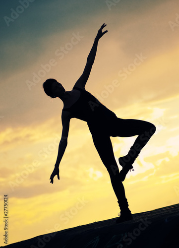 Silhouette of dancing woman over sunset. Yoga © mr.markin