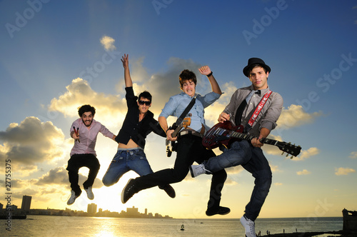 Cuadro en lienzo Group of young male musicians jumping with instruments