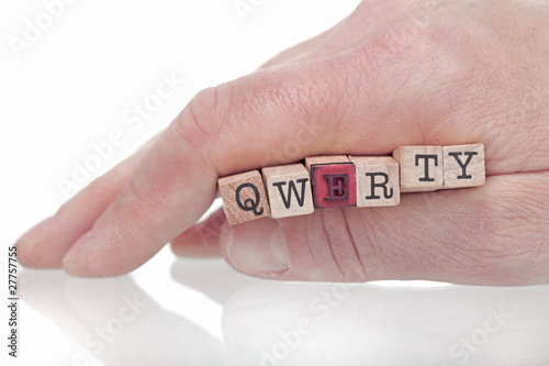 Hand holding "qwerty" made of little wooden stamps