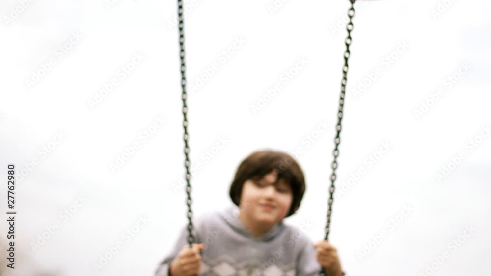 Happy young boy on a swing