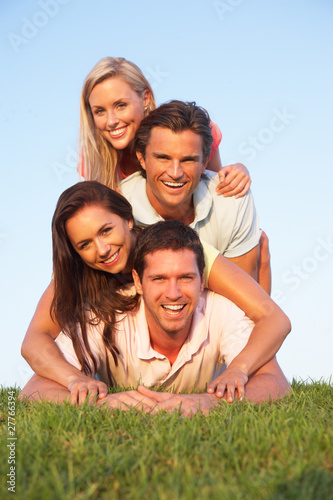 Two  young couples posing on a field