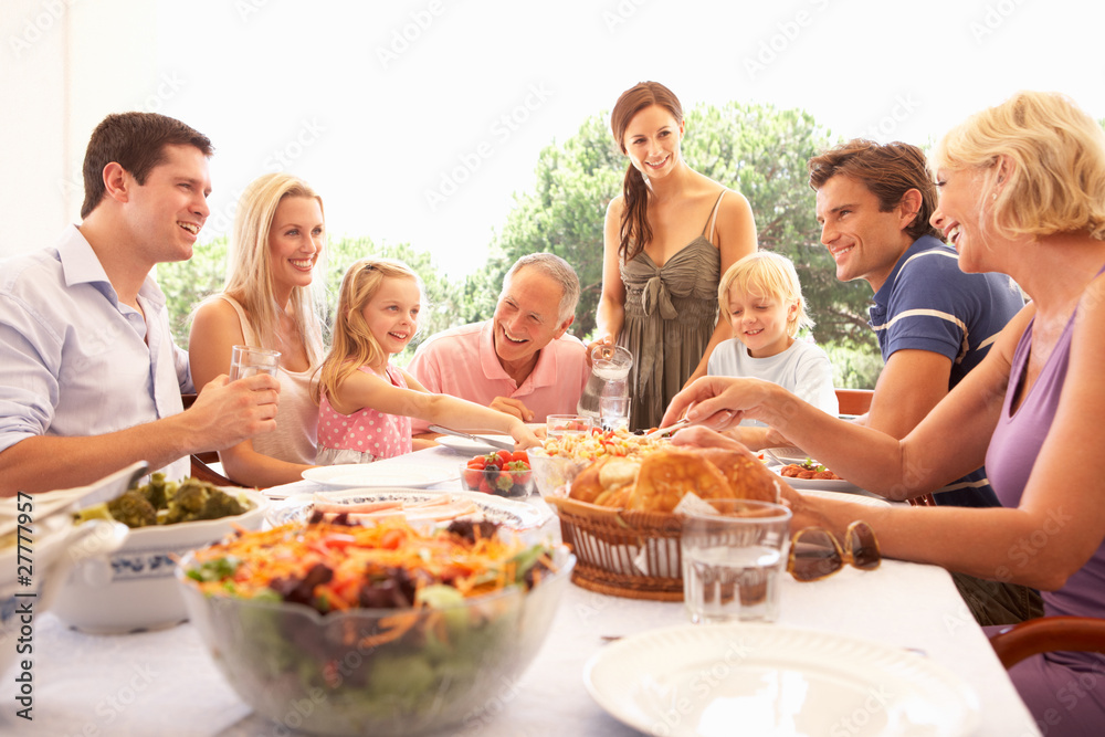 A family, with parents, children and grandparents, enjoy a picni