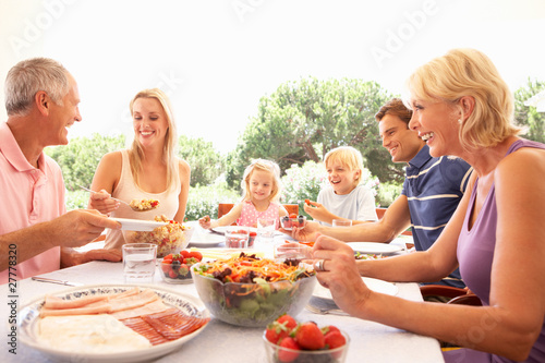 Extended family  parents  grandparents and children  eating outd