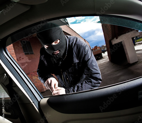 Bild auf Leinwand robber and the thief in a mask hijacks the car