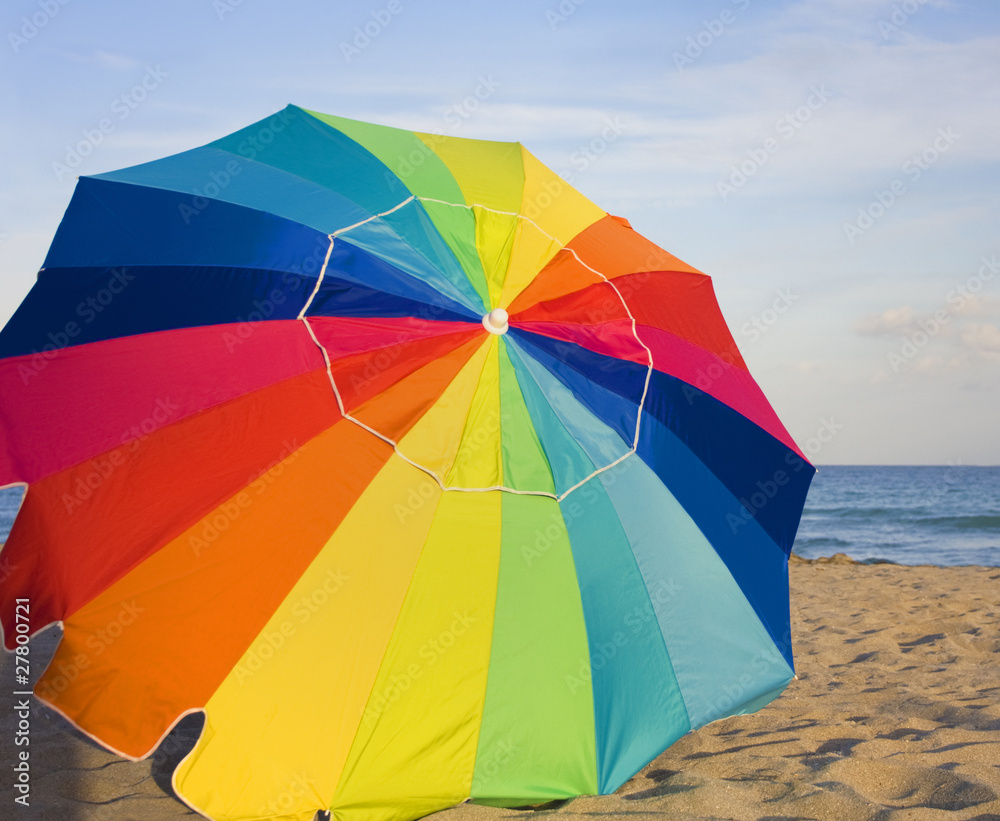 Multicolor umbrella, beach and sea