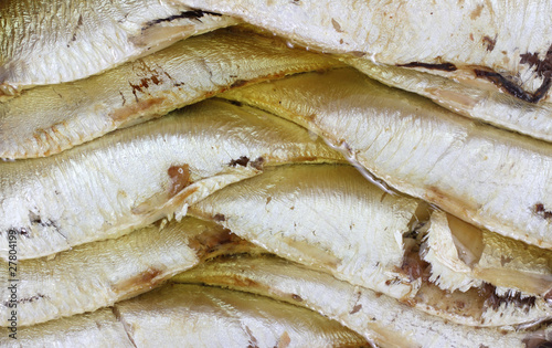 A very close view of several sprats layered for canning.