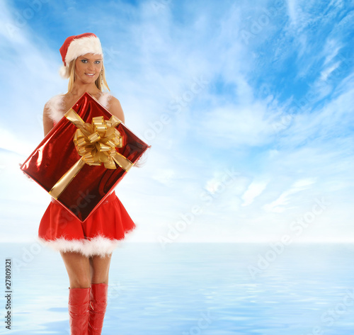 A young blond in a Santa costume holding a present