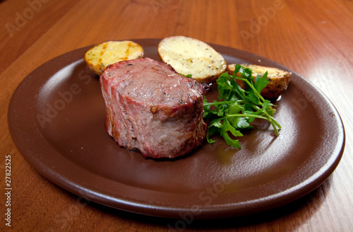 Grilled beef on white plate with potatoes