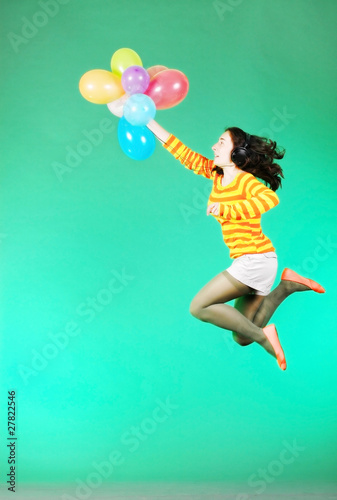 Jumping happy girl with balloons