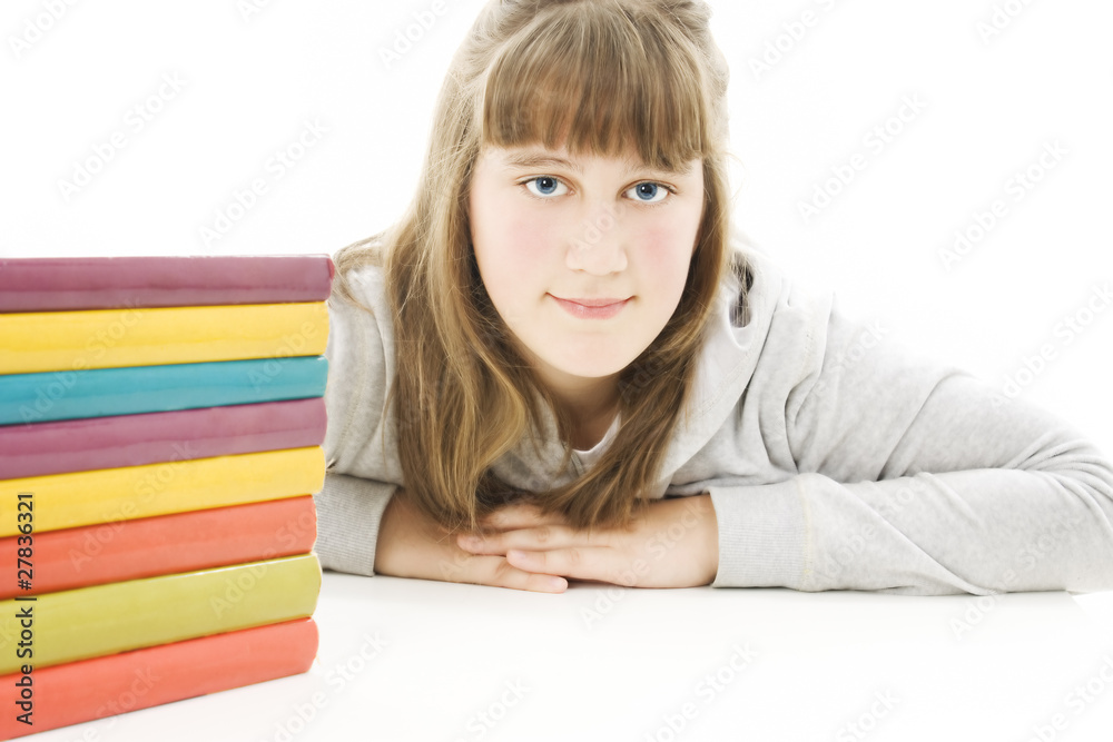 Smiling girl with school books on the table. Isolated on white Smiling girl with school books on the table. Isolated on white