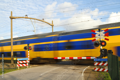 Dutch train passing a railway crossing