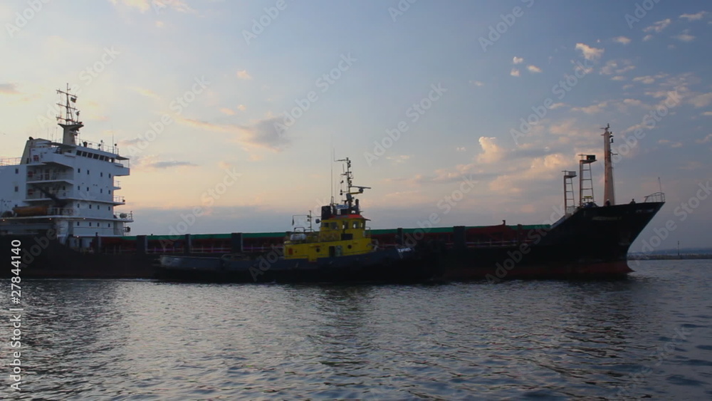 Cargo ship leaves port with tugs assistance time lapse (Full HD) Cargo ship leaves port with tugs assistance time lapse (Full HD)