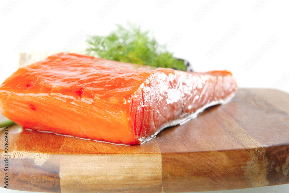 pink smoked salmon on wooden plate with white cheese