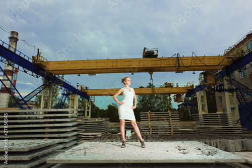 Young businesswoman posing over old factory