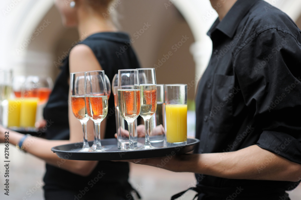 Waiter with dish of wine and juice glasses