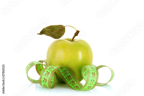 Green apple and tape measure close up