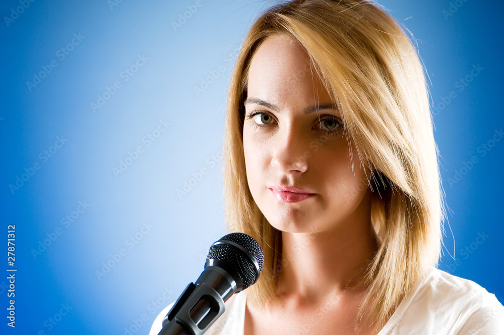 Girl singing with microphone against gradient background Girl singing with microphone against gradient background