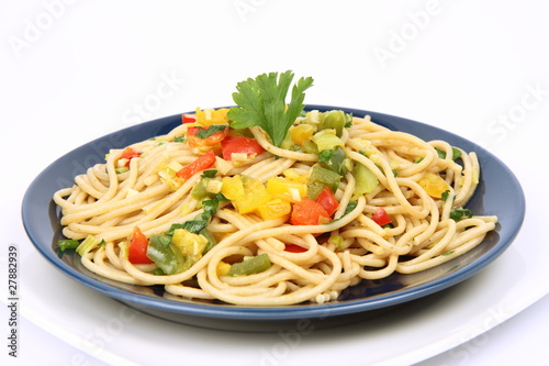 Spaghetti with vegetables on a plate on white background