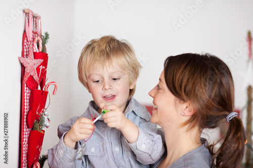 mutter mit glücklichem kind vor dem weihnachtsgeschenk photo