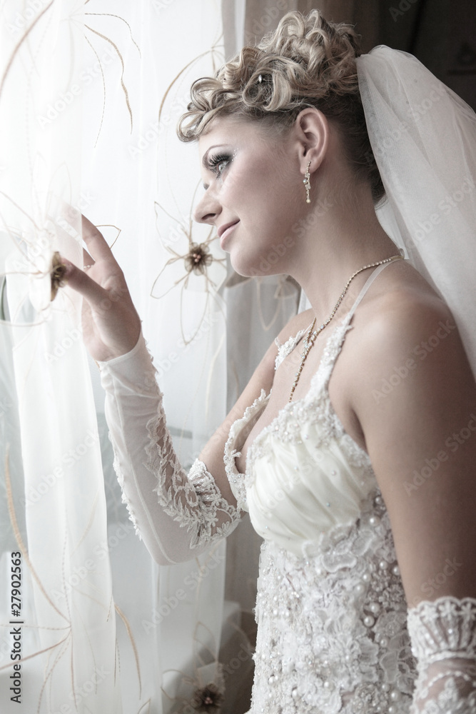 The beautiful bride looks out of the window The beautiful bride looks out of the window