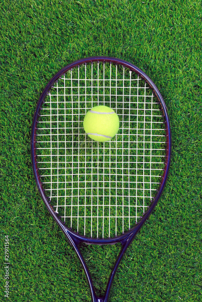 Tennis raquet and ball on grass