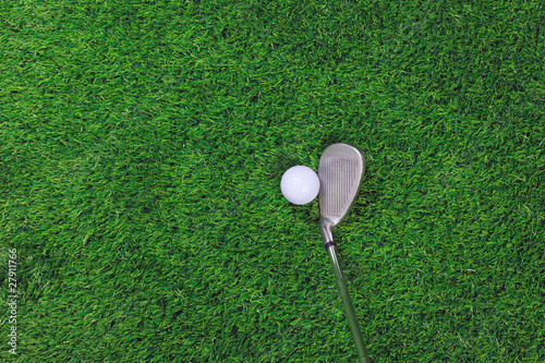 Golf ball and iron club on grass