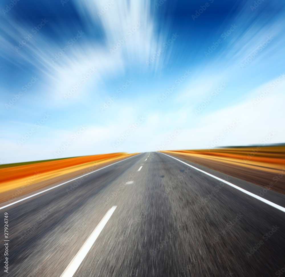 Asphalt blurry road and sky with blurry clouds