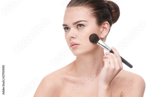 Beautiful young woman applying brush