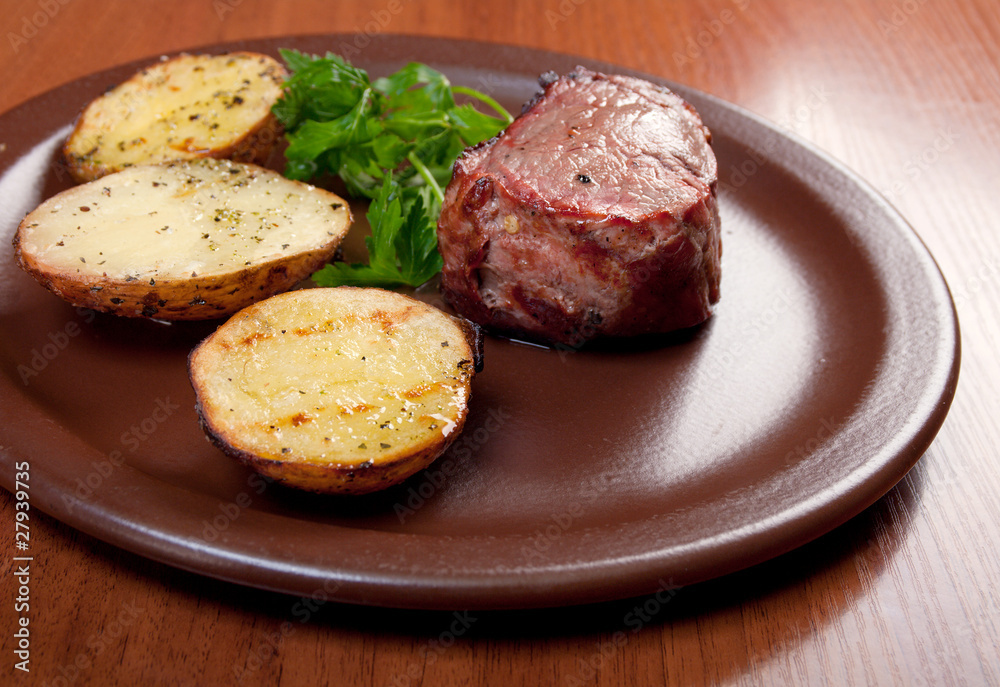 Grilled beef on white plate with potatoes Grilled beef on white plate with potatoes