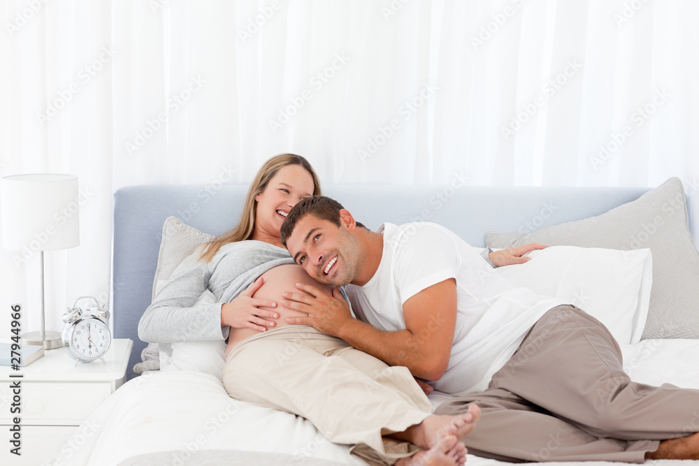 Funny man putting his head on the belly of his pregnant wife Stock Photo |  Adobe Stock