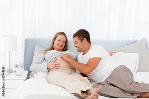 Cute man playing with his pregnant wife