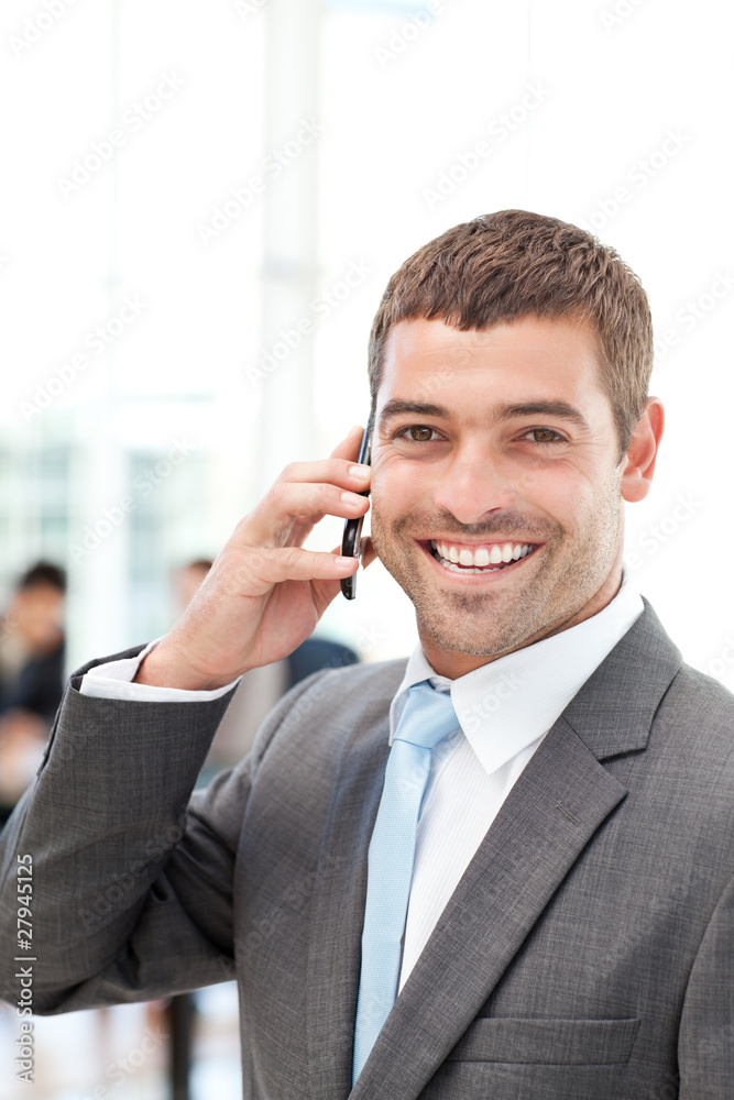 Happy hispanic businessman on the phone while his team is workin Happy hispanic businessman on the phone while his team is workin