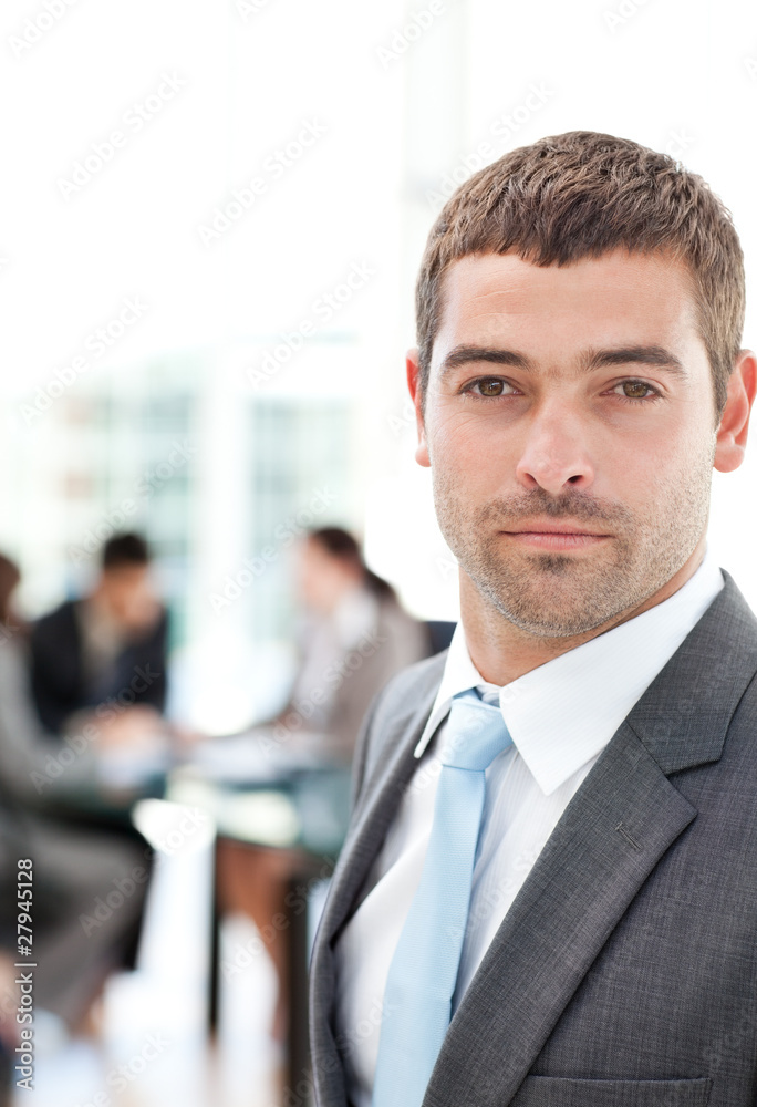 Charismatic businessman standing in the foreground Charismatic businessman standing in the foreground