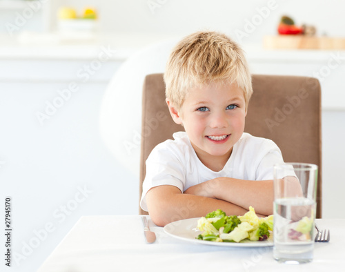 Portrait of a little boy eating a healthy salad for lunch