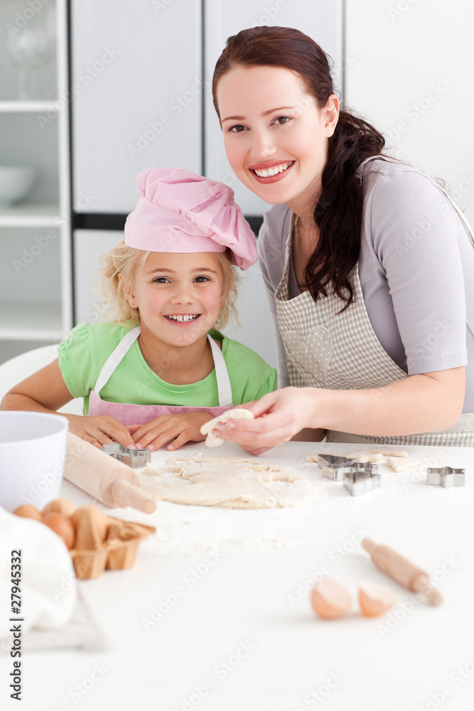 Portrait of a happy mother and daughter kneading a dough Portrait of a happy mother and daughter kneading a dough