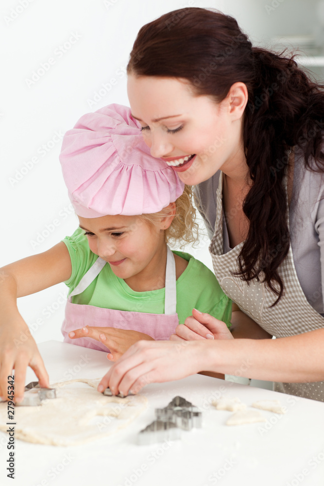 Happy mother and daughter cooking biscuits together Happy mother and daughter cooking biscuits together