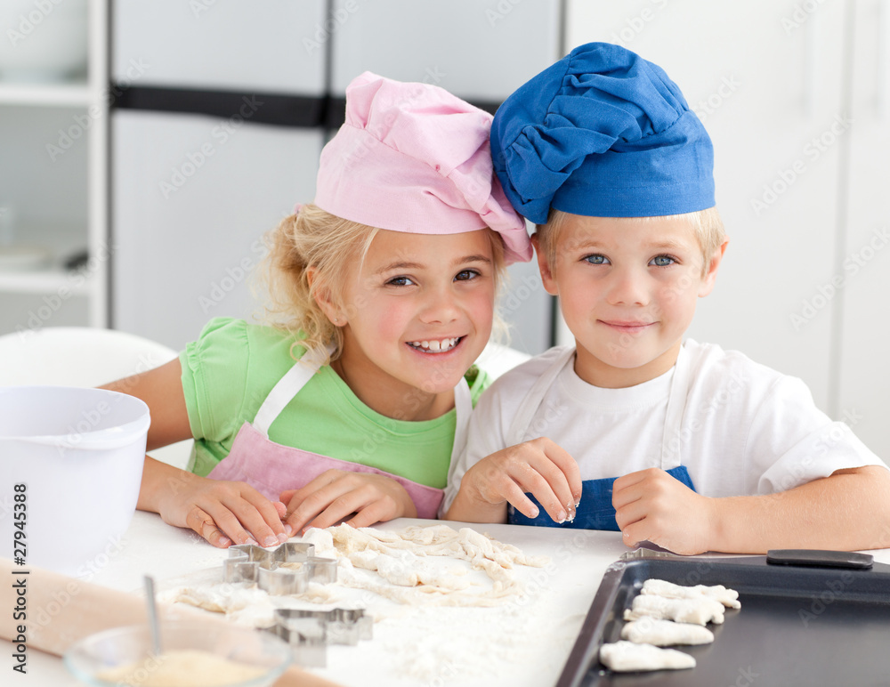 Portrait of two adorable children baking in the kitchen Portrait of two adorable children baking in the kitchen