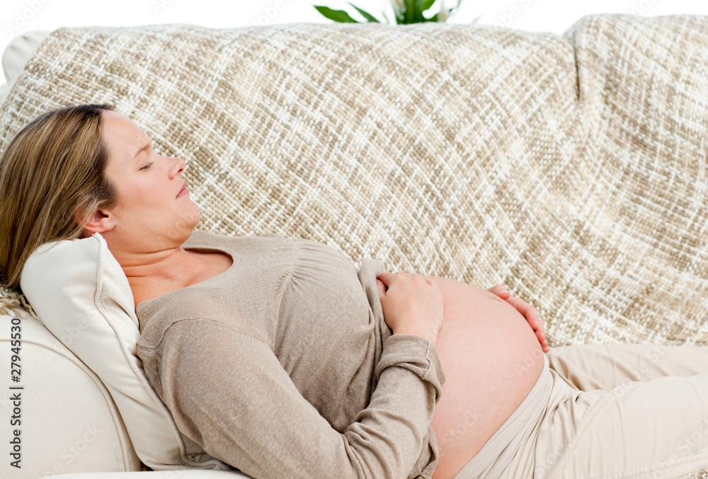 Tired pregnant woman relaxing on her sofa Tired pregnant woman relaxing on her sofa