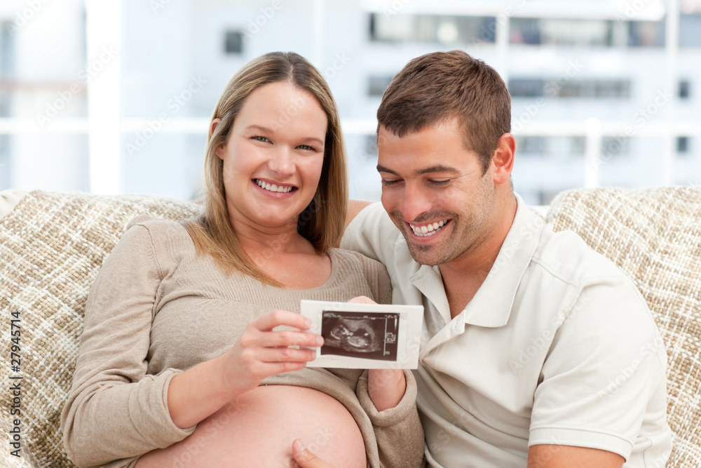 Beautiful pregnant woman showing her echography to her husband Beautiful pregnant woman showing her echography to her husband
