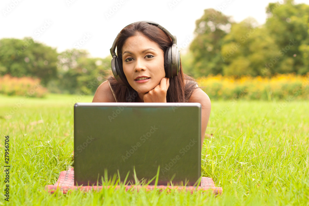 Young lady with laptop in park Young lady with laptop in park