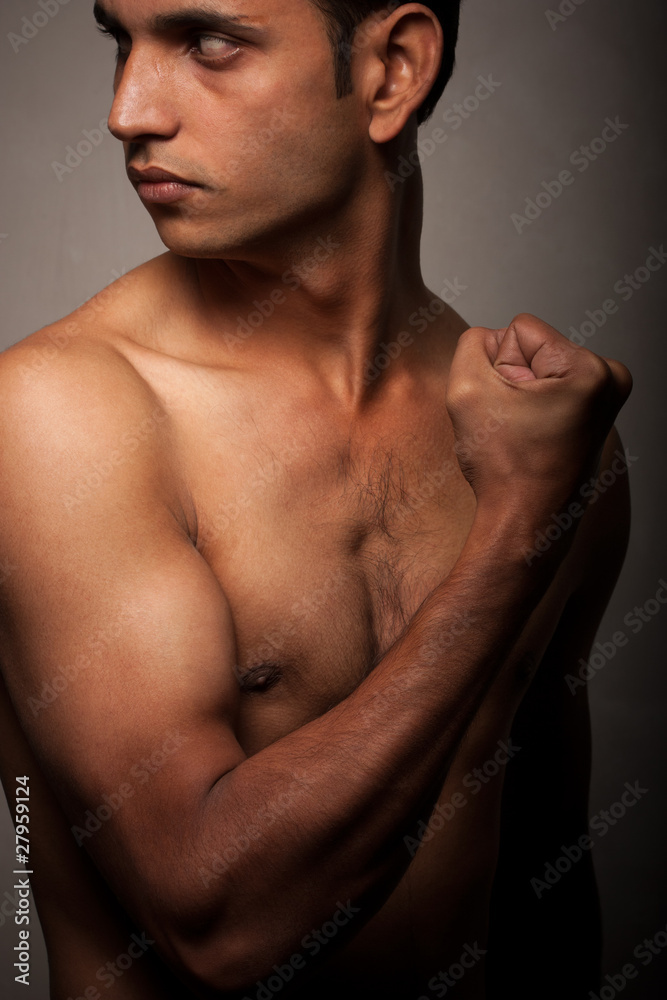 Portrait of young Indian angry man over dark background Portrait of young Indian angry man over dark background