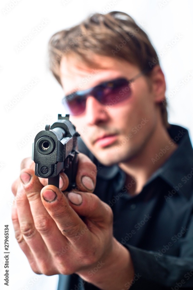 Man holding gun in dirty hands with focus on pistol weraing sun Man holding gun in dirty hands with focus on pistol weraing sun