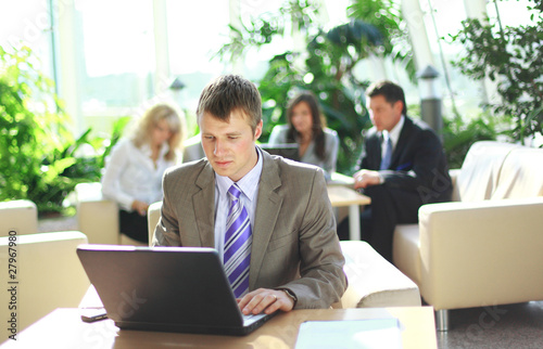 young executive working on a laptop with colleagues