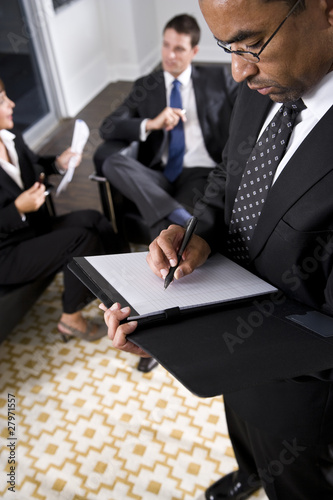 African American businessman writing on notepad