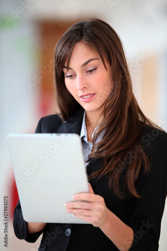 Businesswoman standing in hall with electronic pad